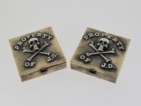 Two brass corner protectors with skull and crossbones design.