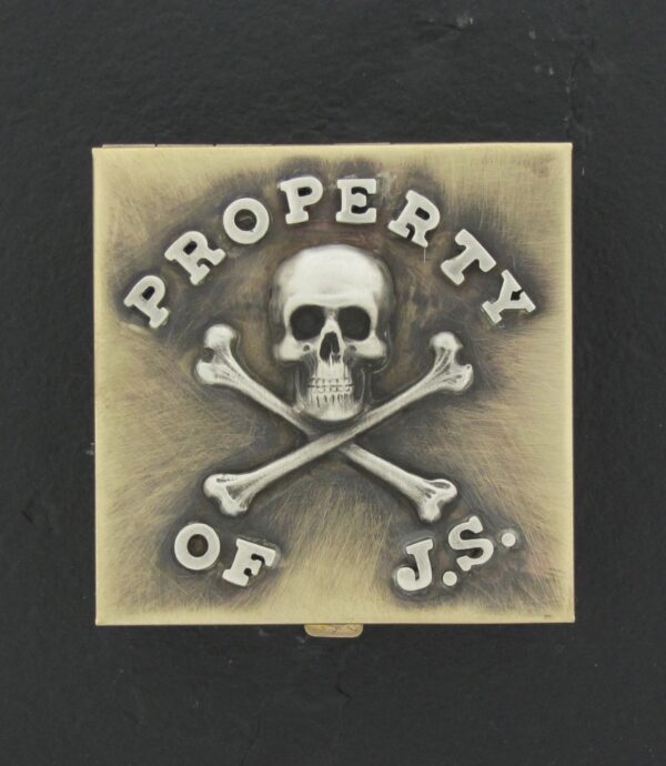 A square tile with a skull and crossbones labeled "Property of J.S.".