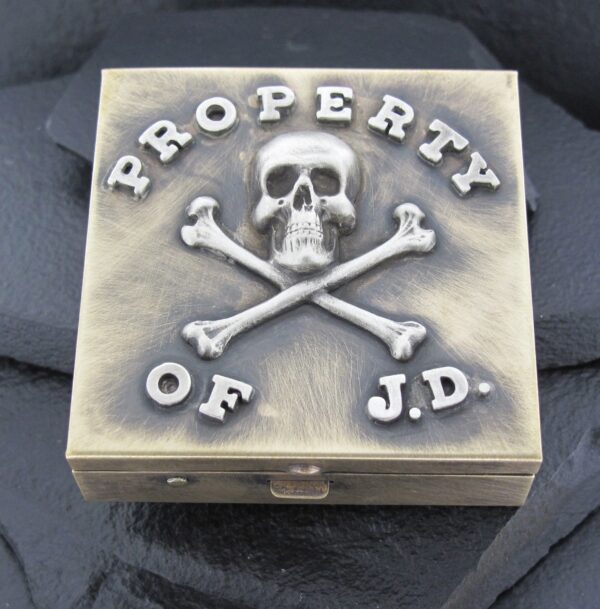A box with a skull, crossbones, and the text 'Property of J.D.' on it.
