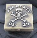 A box with a skull, crossbones, and the text 'Property of J.D.' on it.
