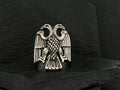 Silver double-headed eagle emblem on black fabric.