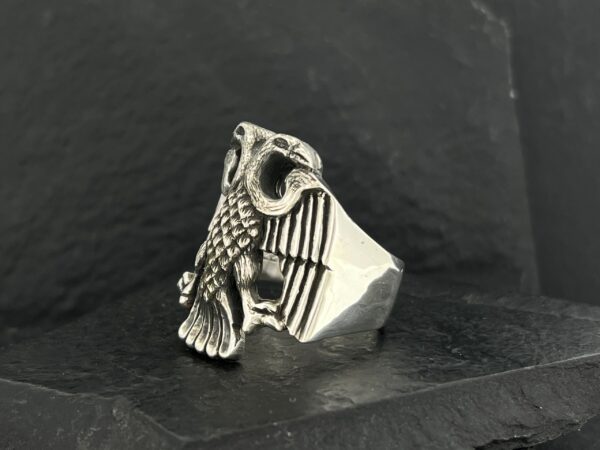 Silver eagle ring with detailed feathers and American flag design.