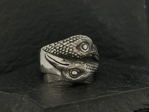 A silver ring shaped like a snake coiled around itself.