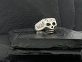 Silver skull ring engraved with 'NEVER TRUST'.