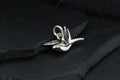 Elegant silver dragonfly pendant on a dark slate surface.