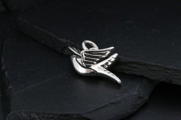 Silver bird charm on a black bracelet.