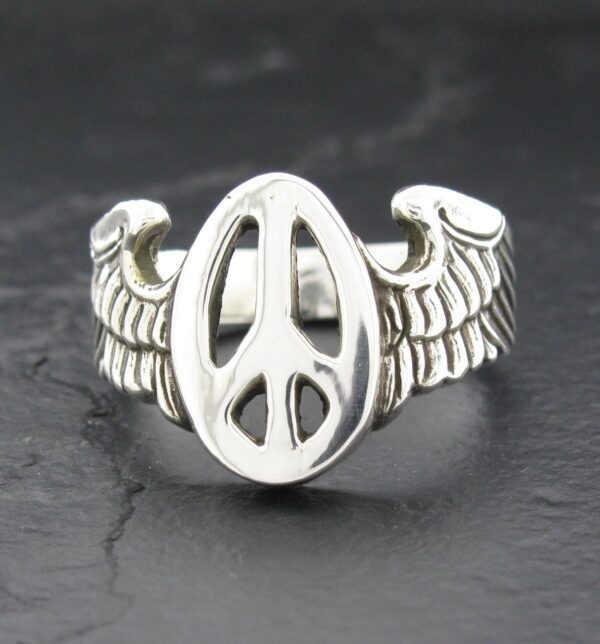 Silver ring with peace symbol and wing designs.