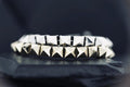 Close-up of silver pyramid-studded bracelets on a dark surface.