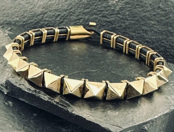 Close-up of a stylish metallic bracelet with pyramid-shaped studs.