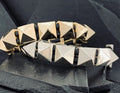 Close-up of a bracelet with pyramid-shaped metallic studs.