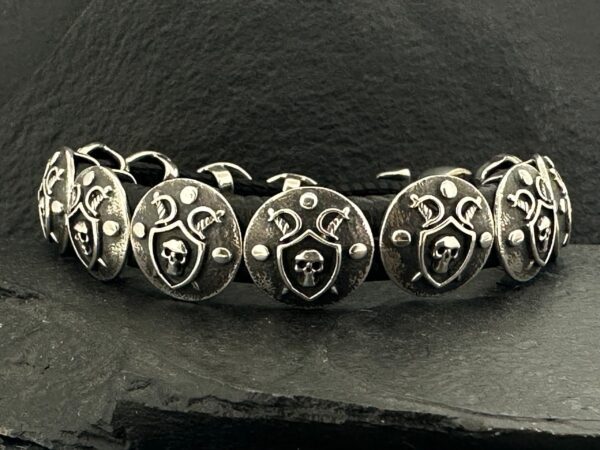 Close-up of a silver bracelet with ornate heart-shaped charms.