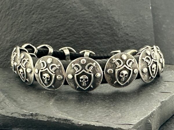 A silver bracelet with heart-shaped charms featuring intricate designs.