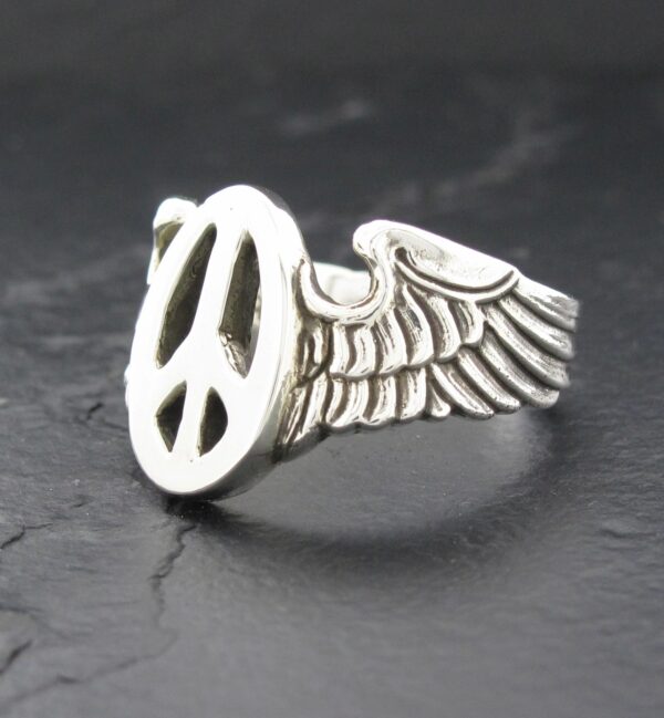 Silver ring with peace symbol and wing design.