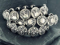 Close-up of intricately designed silver rings with ornate patterns.