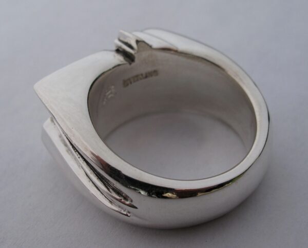 Close-up of a silver ring with a unique, modern design.