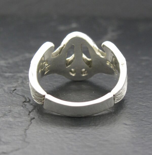 Silver ring with a heart-shaped design and intricate cutouts.