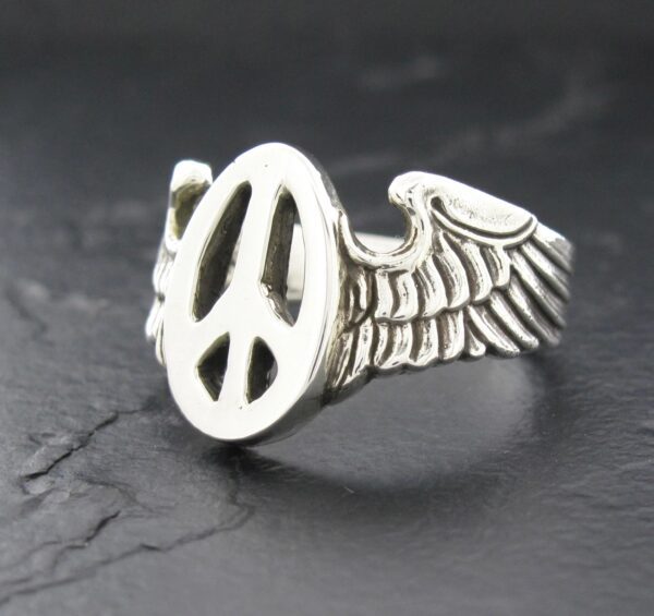 Silver ring with a peace symbol and wing design.