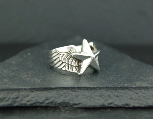 Silver ring with a star and wing design.