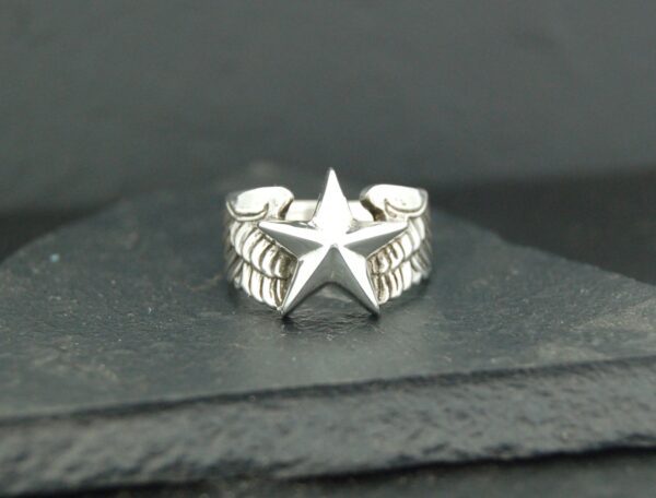 Silver ring with a prominent star design on a textured band.
