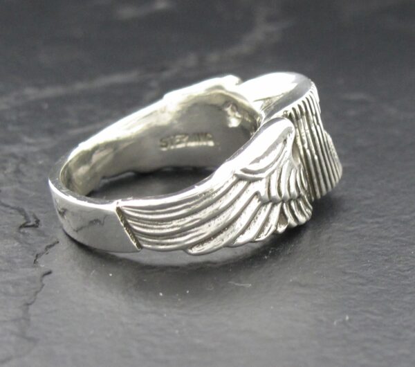 Silver ring featuring detailed angel wings design.