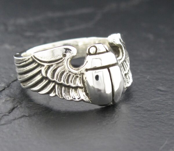 Silver ring featuring a detailed winged grenade design.