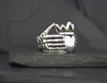 Silver ring shaped like a skeletal hand.