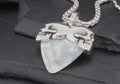 Silver chain necklace with a white, uniquely shaped pendant.