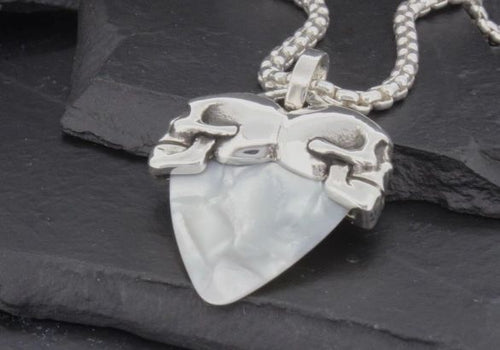 Silver chain necklace with a white, uniquely shaped pendant.