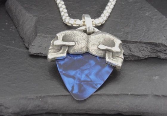 Pendant featuring two stylized skulls and a blue arrowhead.