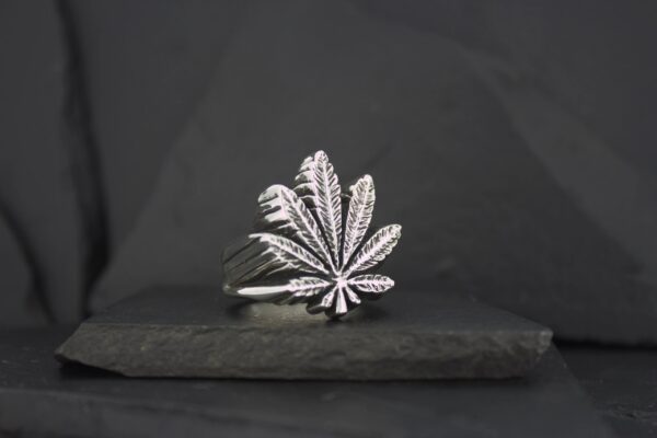 Silver ring featuring a detailed cannabis leaf design.
