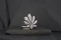 Silver ring featuring a detailed cannabis leaf design.