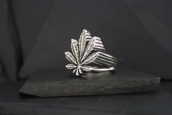 Silver ring shaped like a leaf with intricate details.