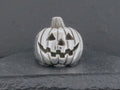 A small silver pumpkin with carved jack-o'-lantern face.