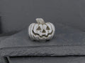 Silver pumpkin charm with a jack-o'-lantern face.