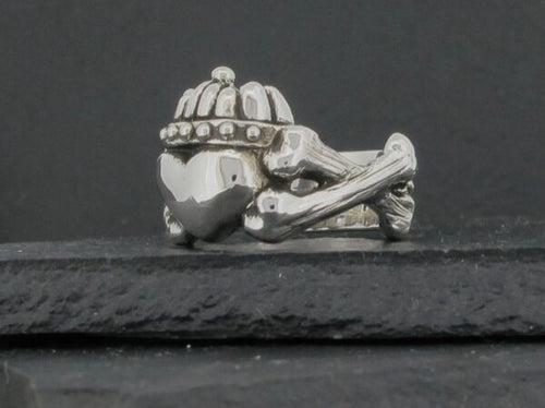 A silver charm shaped like a helmet and crossed bones.