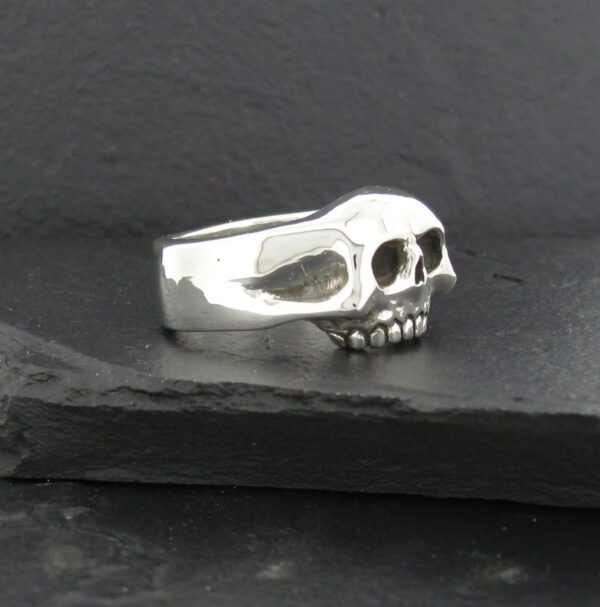 A silver ring featuring a detailed skull design.
