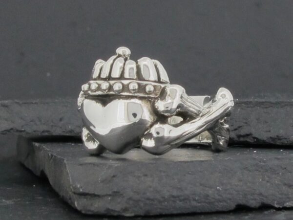 Silver ring with a heart, crown, and crossbones design.