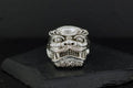 Intricately carved silver ring with a fierce mythical face design.