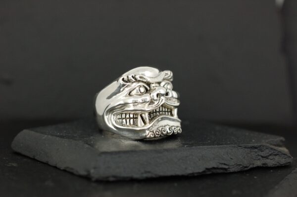 Silver ring featuring an intricate, fierce dragon face design.