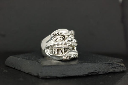 Silver ring featuring an intricate, fierce dragon face design.
