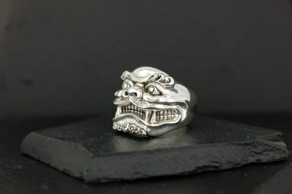 Intricately designed silver ring with a fierce skull motif.