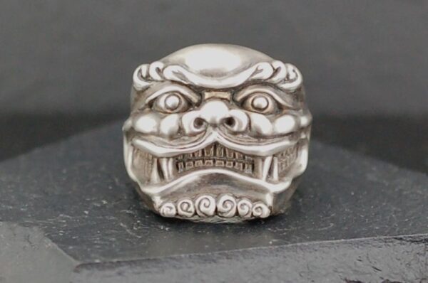 Intricately carved silver lion head bead with detailed facial features.