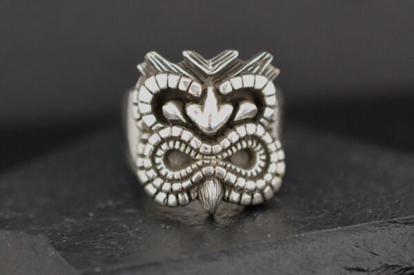Intricately carved tribal-style ring with a bold design.
