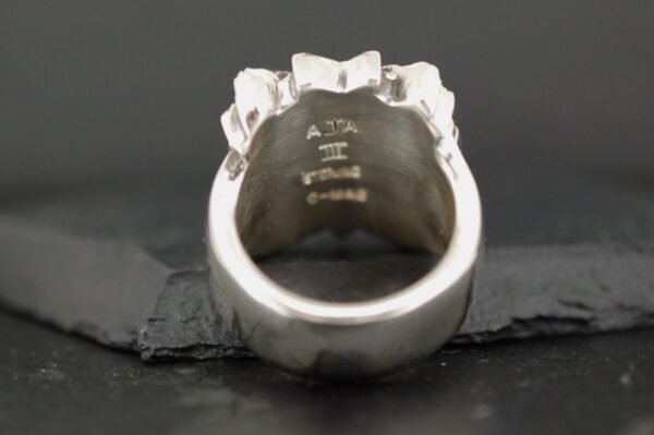 Close-up of a silver ring with engraved markings inside.