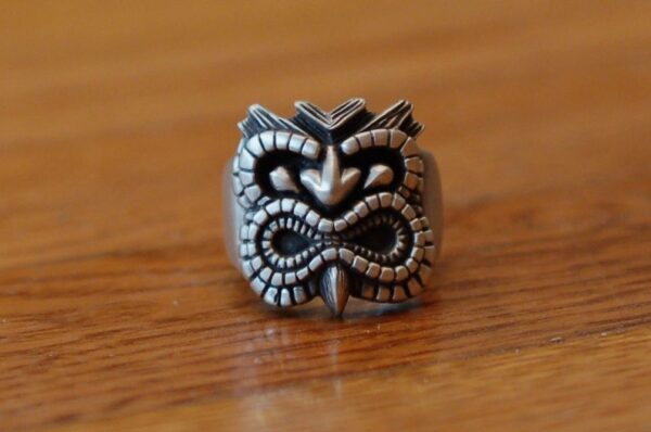 Intricately designed silver ring with a tribal mask motif.