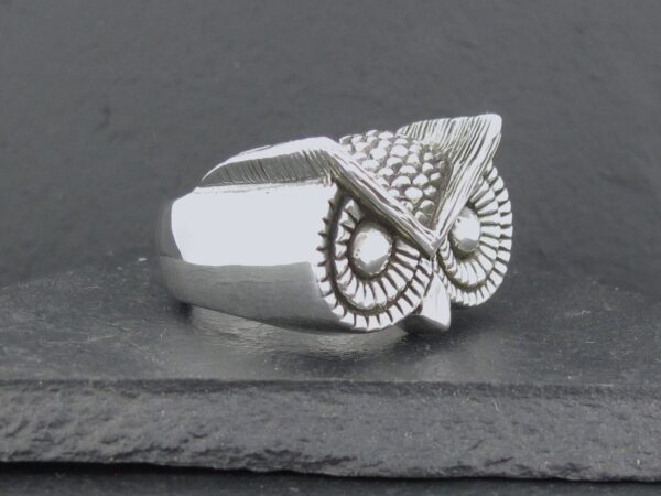 Silver owl-shaped ring with detailed feather design.
