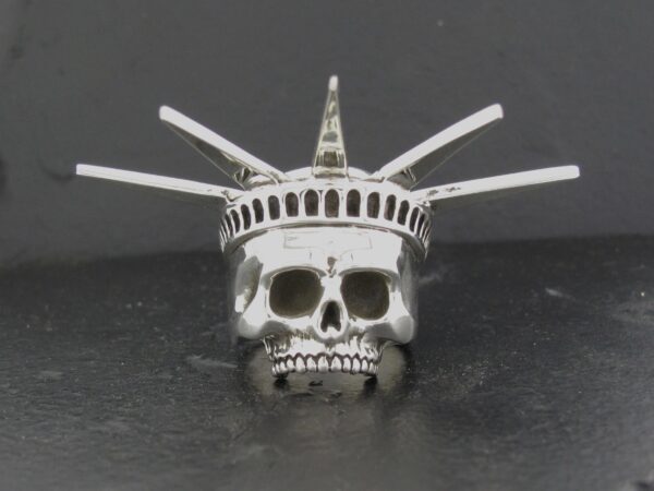A silver skull ring styled like the Statue of Liberty's crown.