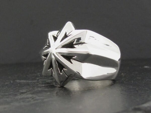 Polished silver ring with a starburst design on top.