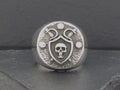 A silver ring featuring a skull and snake design.