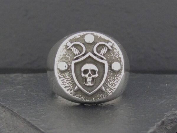 A silver ring featuring a skull and snake design.